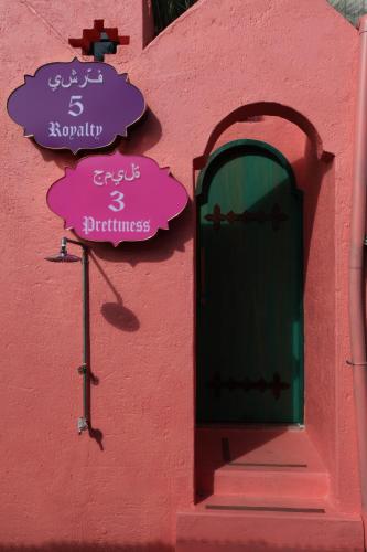 a pink building with a door and signs on it at A Fei Surf Inn III in Nanwan