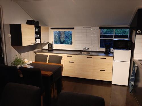 a kitchen with a refrigerator and a table in it at B&B Ebbenbroek in Bruchterveld