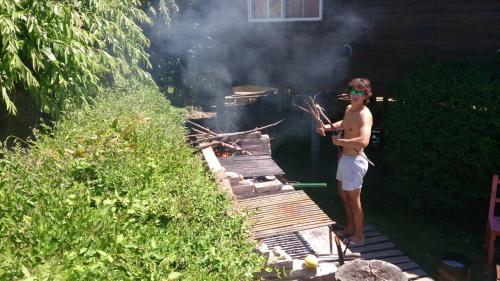 a man is standing in front of a grill at Rio Manso Tigre in Tigre
