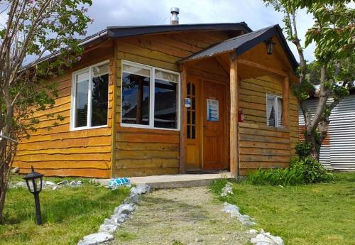 eine kleine Holzhütte mit einer Tür im Hof in der Unterkunft Turismo Don Hugo in Puerto Tranquilo