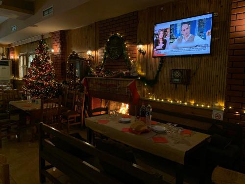 a restaurant with a christmas tree and a tv on the wall at Margaret's Island Hotel in Naousa Imathias