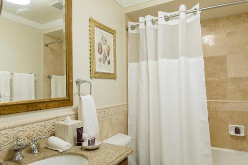 y baño con cortina de ducha y lavamanos. en Great Bay Condominiums located at The Ritz-Carlton Club, St Thomas, en Nazareth