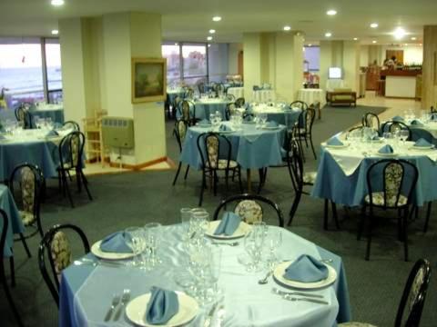 un comedor con mesas y sillas con mantel azul en Playa Club Apart, en Miramar