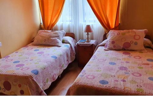 a bedroom with two beds and a window at Hotel Iberia in Coquimbo