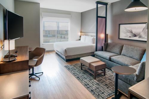 a hotel room with a bed and a couch at Hyatt Place Sioux Falls South in Sioux Falls