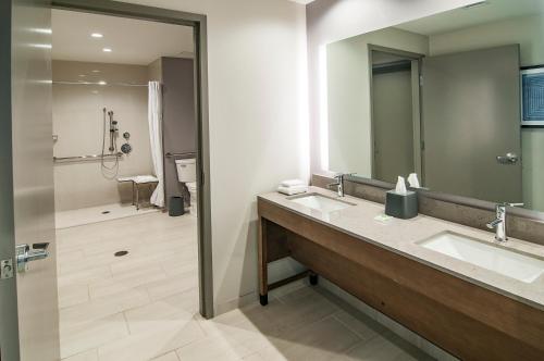 a bathroom with two sinks and a shower at Hyatt Place Sioux Falls South in Sioux Falls