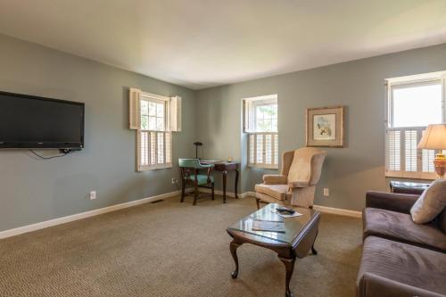 a living room with a couch and a tv at Century Suites Hotel in Bloomington