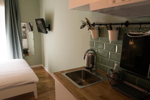 eine Küche mit einem Waschbecken und ein Bett in einem Zimmer in der Unterkunft S&L1 REPUBLIC ZAGREB CENTER in Zagreb