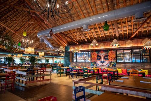 a restaurant with colorful tables and chairs and a large room at Bahia Principe Grand Tulum - All Inclusive in Akumal