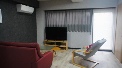 a living room with a couch and a television at Compass in Nagano