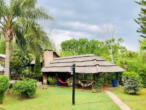 a hut with a thatched roof in a garden at Rio Manso Tigre in Tigre
