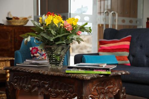 a table with a vase of flowers on it at Atoq San Blas Hotel in Cusco