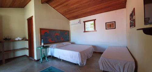 a bedroom with two beds and a window at Hospedaria Rosa dos Ventos in Marataizes