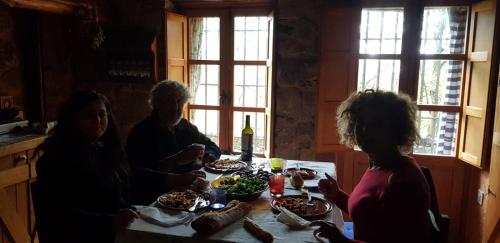 a group of people sitting around a table with food at Cabaña Castañarejo in Candeleda