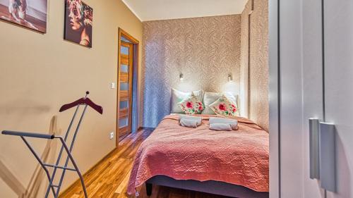 希维拉杜夫-兹德鲁伊Apartament Spokojny Holiday Mountain Residence - 5D Apartamenty的卧室里有一张床，床罩是粉色的