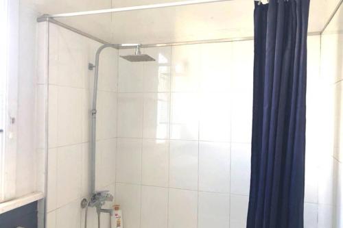 a shower with a blue curtain in a bathroom at Modern Charming Miners’ Cottage +Free Internet in Broken Hill