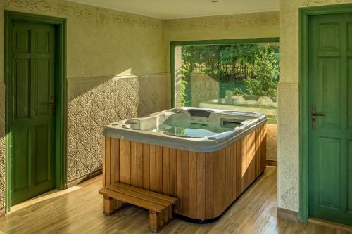 a jacuzzi tub in a room with two doors at Páskom Cottage in Lajoskomárom