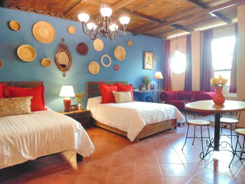 a bedroom with two beds and a table and a couch at Suites Portal San Ángel I Hospedaje Ejecutivo in Mexico City