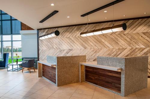 an office lobby with a stone counter and wooden wall at Hyatt Place Sioux Falls South in Sioux Falls