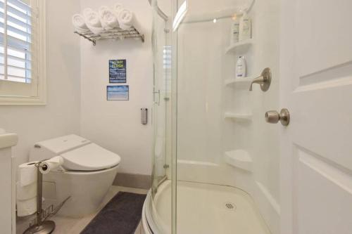 a bathroom with a toilet and a glass shower at 1000#3 Renovated Home by Beach & Sand - AC & More! in Newport Beach