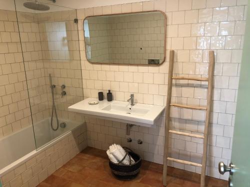 a bathroom with a sink and a shower and a mirror at Casa do Côvo - Suite in Porto Covo
