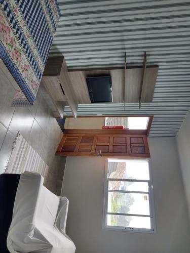 a small kitchen with a window and a white chair at Casa Nova Bertioga - SESC - Vista Linda - Riviera - Prainha Branca in Bertioga