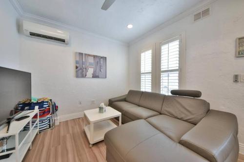 a living room with a couch and a tv at 1000#4 Modern Beach Home, Steps from Sand w/AC! in Newport Beach