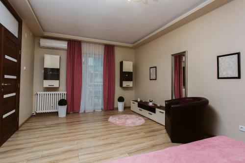 a bedroom with a bed and a large window at Vively Lux Apartment - Central & Spacious with Balcony and free WiFi in Subotica