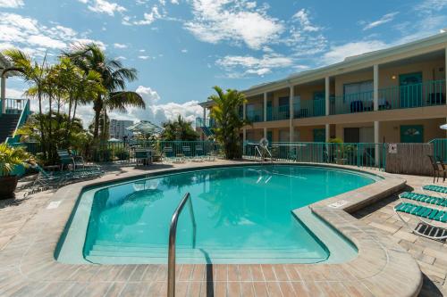 a swimming pool at a resort with chairs and a building at Five Palms Vacation Rentals- Daily - Weekly - Monthly in Clearwater Beach
