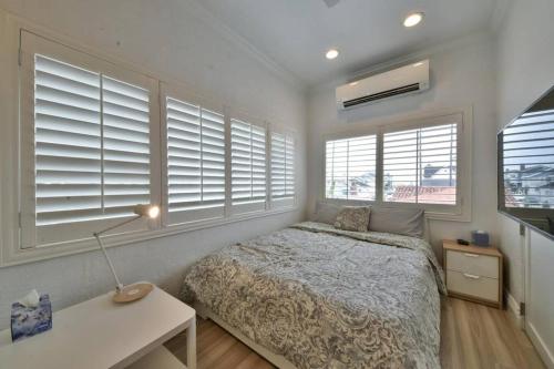 1 dormitorio con 1 cama, escritorio y ventanas en 1000#5 Premier Modern Home w View, Parking, and AC, en Newport Beach