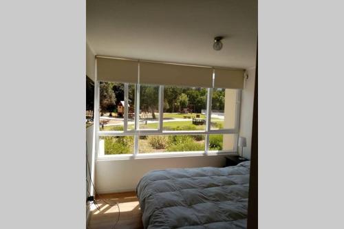 a bedroom with a bed and a large window at MARAVILLOSO DEPARTAMENTO EN PAPUDO ,primer piso in Papudo