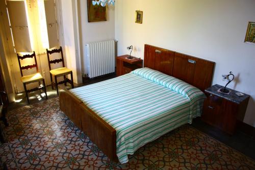 a bedroom with a bed and two chairs in it at B&B Sotto i Pini in Zafferana Etnea