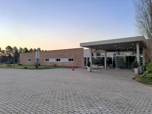 a brick building with a parking lot in front of it at Hotel Juana de Ibarbourou in Melo