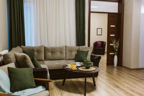 a living room with a couch and a table at Vively Lux Apartment - Central & Spacious with Balcony and free WiFi in Subotica