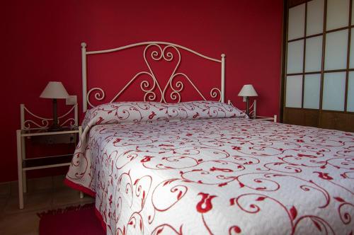 a red bedroom with a large bed with a white bedspread at Apartamentos Barrena in Albarracín