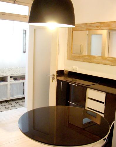 a kitchen with a black table and a mirror at Apartamentos Casa del Coronel in Tarifa