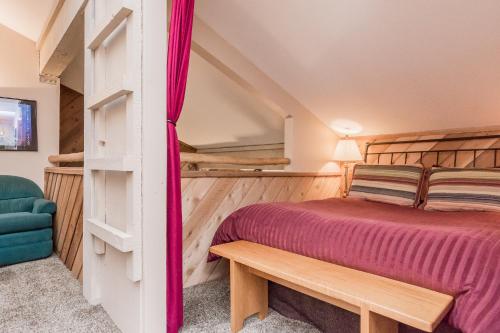 Un dormitorio con una cama y un banco en una habitación. en Crestview -B # 46, en Mammoth Lakes