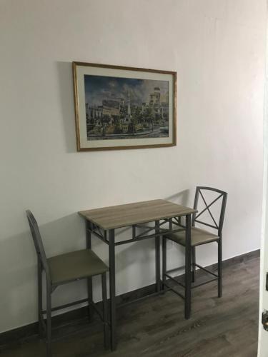 a table and two chairs and a picture on a wall at 310Guest-House La Vida in San Juan
