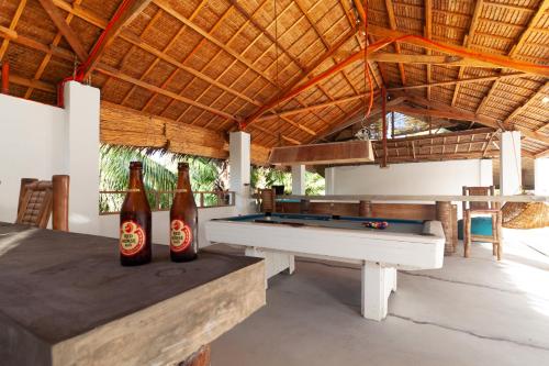 Habitación con mesa de billar y 2 botellas de cerveza en Sunlit Hostel, en General Luna