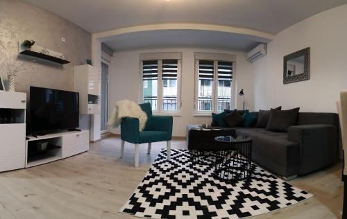 a living room with a couch and a tv at Apartman SILVER in Sremska Mitrovica