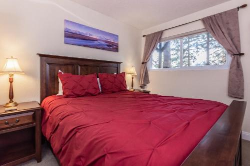 Un dormitorio con una cama roja y una ventana. en Mammoth View Villas # 34, en Mammoth Lakes