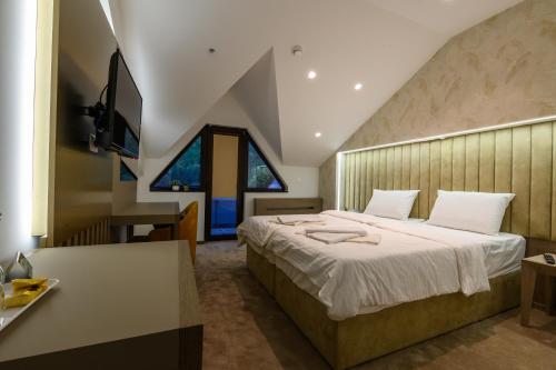 ein Schlafzimmer mit einem großen Bett und einem Schreibtisch in der Unterkunft Euro Hotel Gradche in Kočani