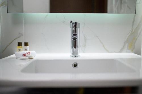 a bathroom sink with a faucet on top of it at Hotel Gradche in Kochani