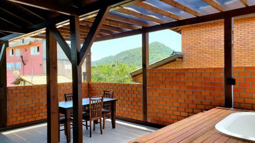 a patio with a table and chairs on a deck at Pousada Doce Mar in Guarda do Embaú