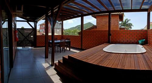 a bath tub on a wooden deck with a table at Pousada Doce Mar in Guarda do Embaú