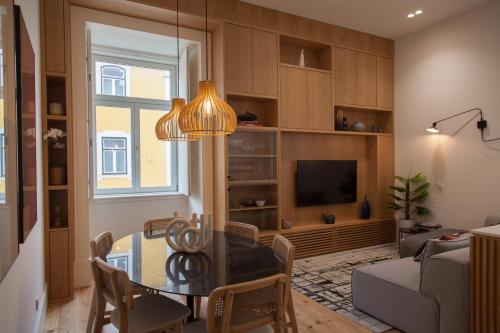 a living room with a dining room table and a television at FLH Praça Comércio Tropical Flat in Lisbon