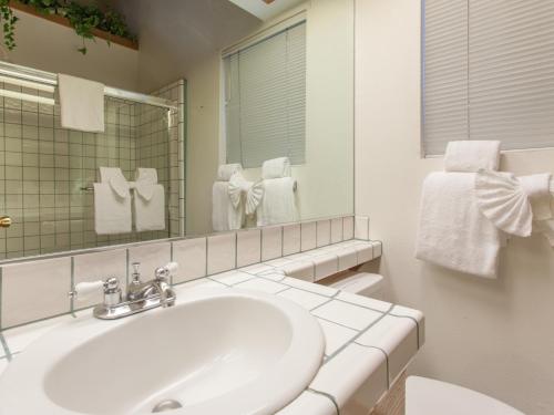 a white bathroom with a sink and a mirror at Val d'lsere # 21 in Mammoth Lakes