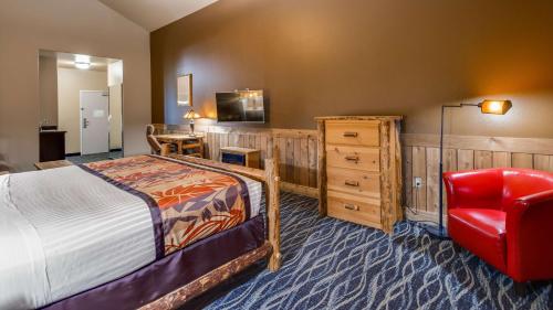 a bedroom with a bed and a red chair at Best Western Plus Battleground Inn & Suites in Battle Ground