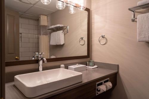 a bathroom with a white sink and a mirror at Best Western Gold Rush Inn in Whitehorse