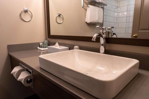 a bathroom with a white sink and a mirror at Best Western Gold Rush Inn in Whitehorse
